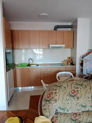 a kitchen with a table and a kitchen with wooden cabinets at Apartman centar Bar in Svijetin Brijeg