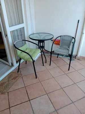 two chairs and a glass table and chairs on a porch at Apartman centar Bar in Svijetin Brijeg