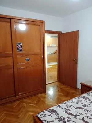 a bedroom with a large wooden cabinet and a door at Apartman centar Bar in Svijetin Brijeg