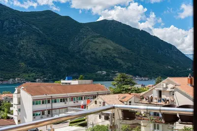 a view of a building with mountains in the background at Vista Apartment in Kotor