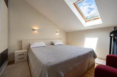 a bedroom with a bed and a skylight at Vista Apartment in Kotor