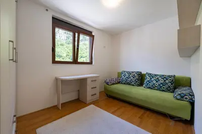 a living room with a green couch and a desk at Vista Apartment in Kotor