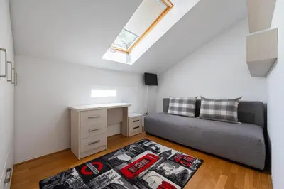a bedroom with a bed and a desk and a window at Vista Apartment in Kotor
