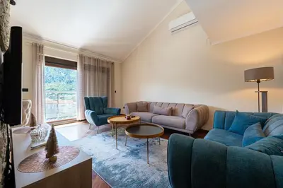 a living room with a blue couch and chairs at Vista Apartment in Kotor
