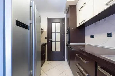a kitchen with a stainless steel refrigerator and a hallway at Vista Apartment in Kotor