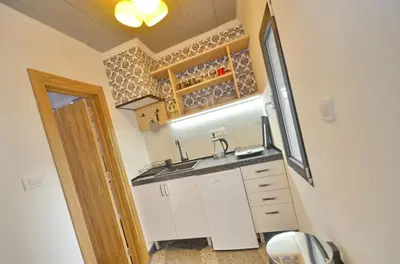 a small kitchen with a sink and a mirror at Apartments Spasoje 1 in Dobrota