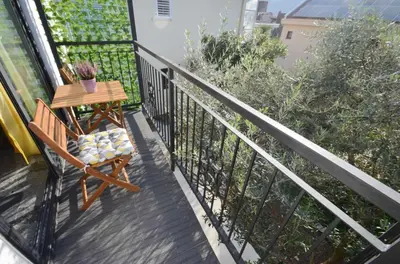 a balcony with a table and a chair on it at Apartments Spasoje 1 in Dobrota