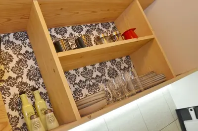 a wooden cabinet with dishes and glasses in it at Apartments Spasoje 1 in Dobrota