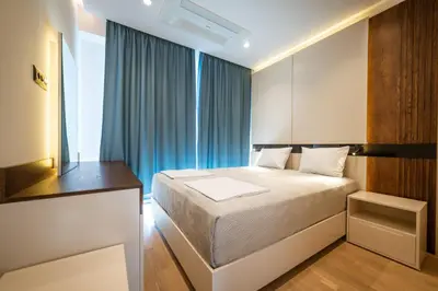 a small bedroom with a bed and a window at Bellemond Hotel & Residences in Budva