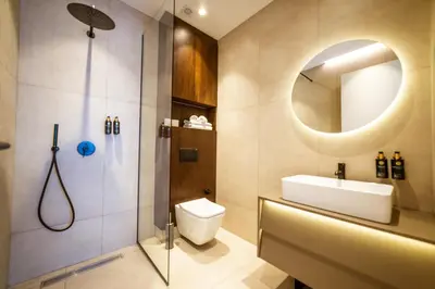 a bathroom with a toilet and a sink and a mirror at Bellemond Hotel & Residences in Budva
