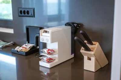 a coffee machine sitting on a table with a phone at Bellemond Hotel & Residences in Budva