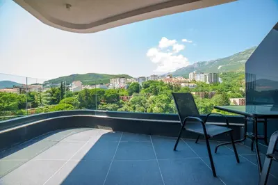 a balcony with a table and chairs and a view at Bellemond Hotel & Residences in Budva