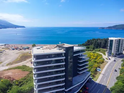 an aerial view of a building with the ocean in the background at Bellemond Hotel & Residences in Budva