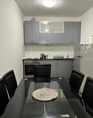 a kitchen with a glass table and black chairs at Citadela Old Town Budva in Budva