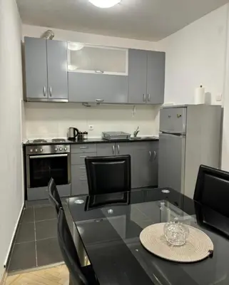 a kitchen with a black table and chairs and a stove at Citadela Old Town Budva in Budva