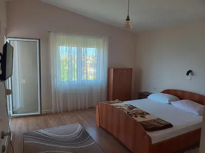 a bedroom with a large bed and a window at Jasmin 1 in Ulcinj