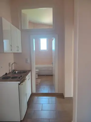 a kitchen with a sink and a door to a bathroom at Jasmin 1 in Ulcinj