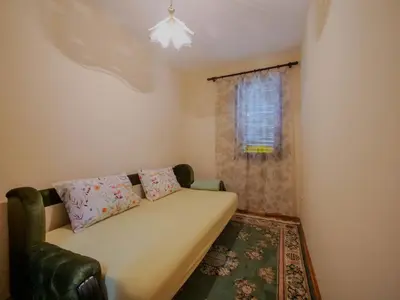 a small room with a couch and a window at Apartman Baranka in Bar