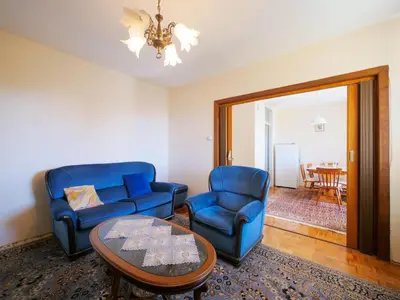 a living room with two blue chairs and a table at Apartman Baranka in Bar
