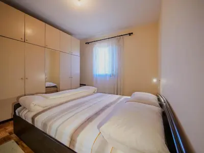 a bedroom with two beds and a window at Apartman Baranka in Bar