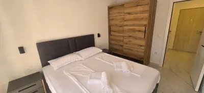 a bedroom with a white bed with two towels on it at Kosara apartman Velika Plaža Ulcinj in Ulcinj