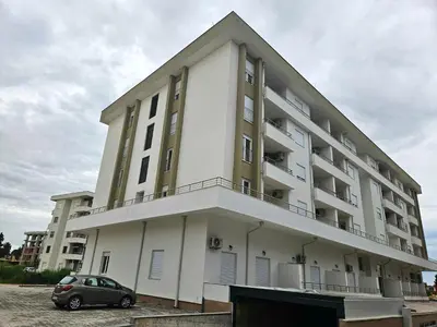 a building with a car parked in front of it at Kosara apartman Velika Plaža Ulcinj in Ulcinj