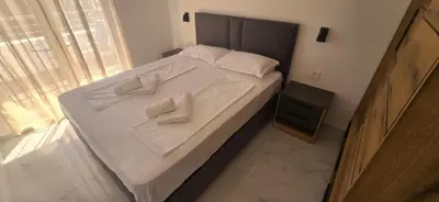 a large bed with two white towels on it at Kosara apartman Velika Plaža Ulcinj in Ulcinj