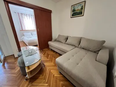 a living room with a couch and a glass table at Alpha Centrum in Bar