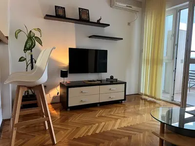 a living room with a tv and a chair and a table at Alpha Centrum in Bar