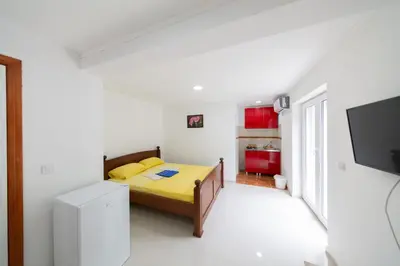 a bedroom with a yellow bed in a white room at King`s Heaven Apartments in Budva