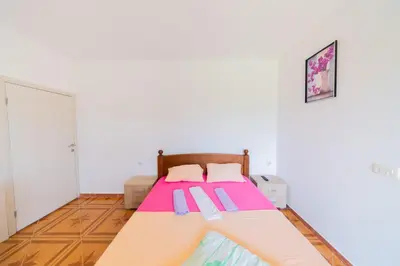 a bedroom with a bed with pink and purple sheets at King`s Heaven Apartments in Budva