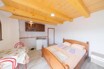 a bedroom with a bed and a table and a kitchen at King`s Heaven Apartments in Budva