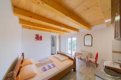 a bedroom with a bed and a table in a room at King`s Heaven Apartments in Budva