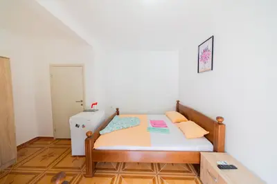 a small bedroom with a bed and a refrigerator at King`s Heaven Apartments in Budva