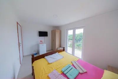 a bedroom with a yellow bed with towels on it at King`s Heaven Apartments in Budva
