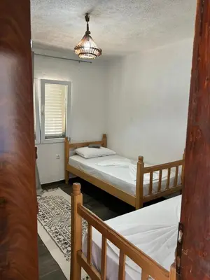 a bedroom with two beds and a chandelier at Prestige House in Dobra Voda
