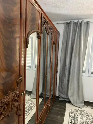a bedroom with a wooden bed and a mirror at Prestige House in Dobra Voda