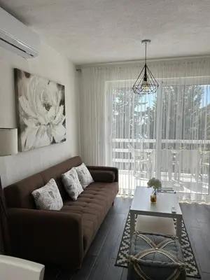 a living room with a brown couch and a table at Prestige House in Dobra Voda