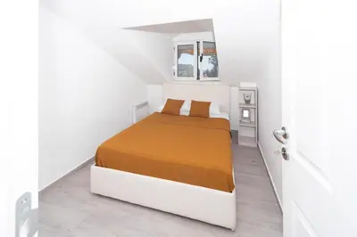 a white bedroom with a bed in a white room at Central comfy apartment in Budva