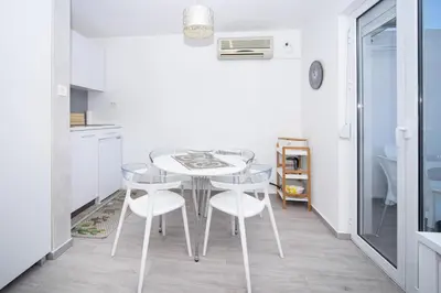a kitchen with a table and chairs in a room at Central comfy apartment in Budva
