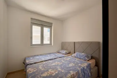 a bedroom with two beds and a window at Summer Apartment with pool in Petrovac na Moru