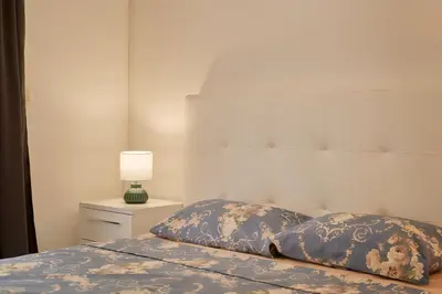 a bedroom with a bed and a lamp on a night stand at Summer Apartment with pool in Petrovac na Moru