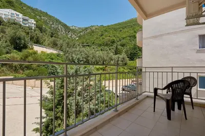 a balcony with a chair and a view of a mountain at Summer Apartment with pool in Petrovac na Moru