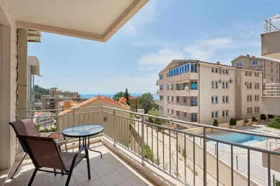 a balcony with a table and chairs and a view at Summer Apartment with pool in Petrovac na Moru