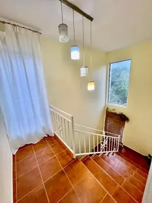 a room with a staircase with a white curtain and a window at Olive Hill Home in Becici
