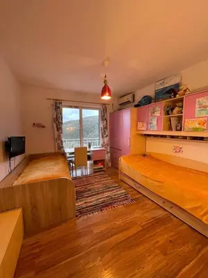 a bedroom with two beds and a desk and a window at Olive Hill Home in Becici