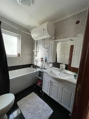 a bathroom with a tub and a sink and a toilet at Olive Hill Home in Becici