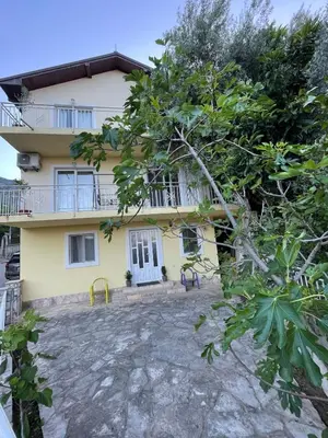a large yellow house with a balcony at Olive Hill Home in Becici
