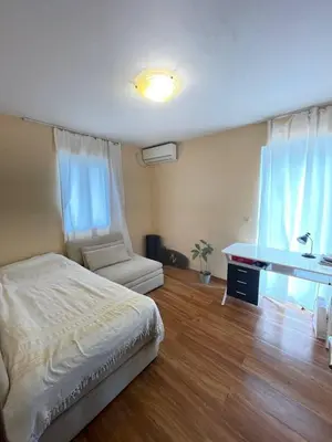 a bedroom with a bed and a desk and a window at Olive Hill Home in Becici