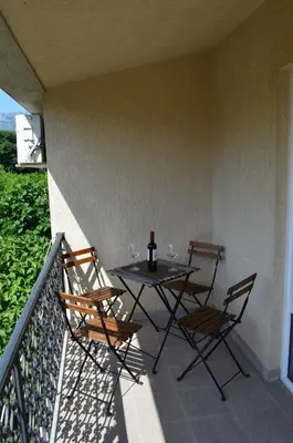 a patio with a table and chairs on a balcony at Lovely 1BR Apartment 5min of walk from city center in Bar
